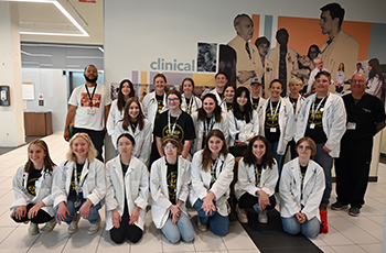 Students will have the opportunity to travel to the Bowman Gray Center for Medical Education during the 2024 Camp Med Summer Program.Group of high school students in white lab coats posing for a photo.
