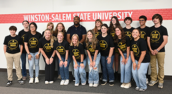 Students in grades 9-12 enjoyed a week of healthcare learning opportunities during the Camp Med Summer Program.High school boys and girls smiling in front of Winston-Salem State University Sign.